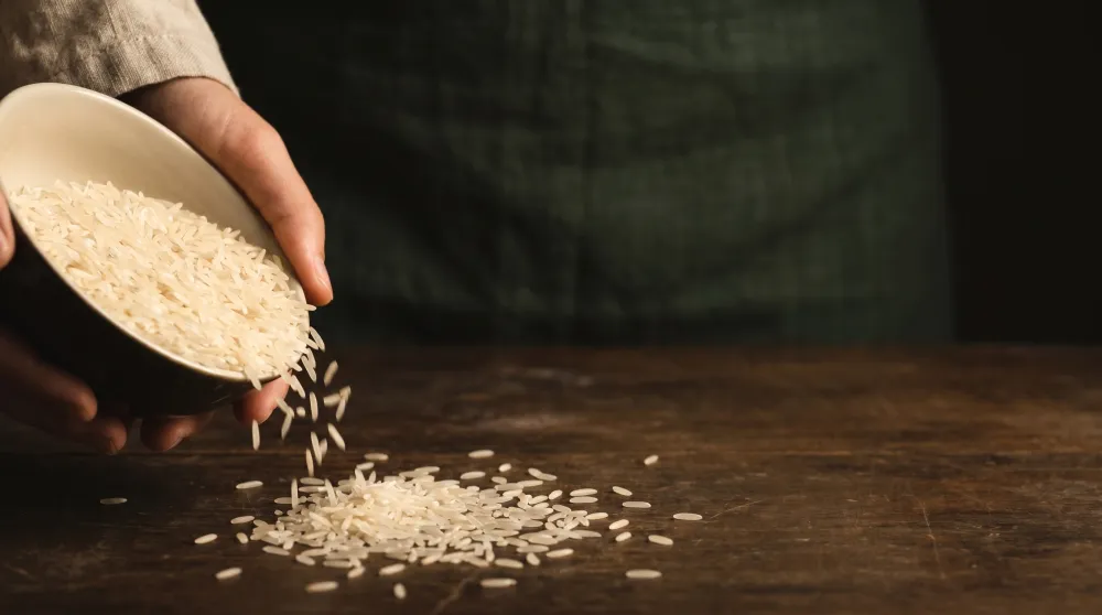 Illustrative rice being poured from a bowl onto a table